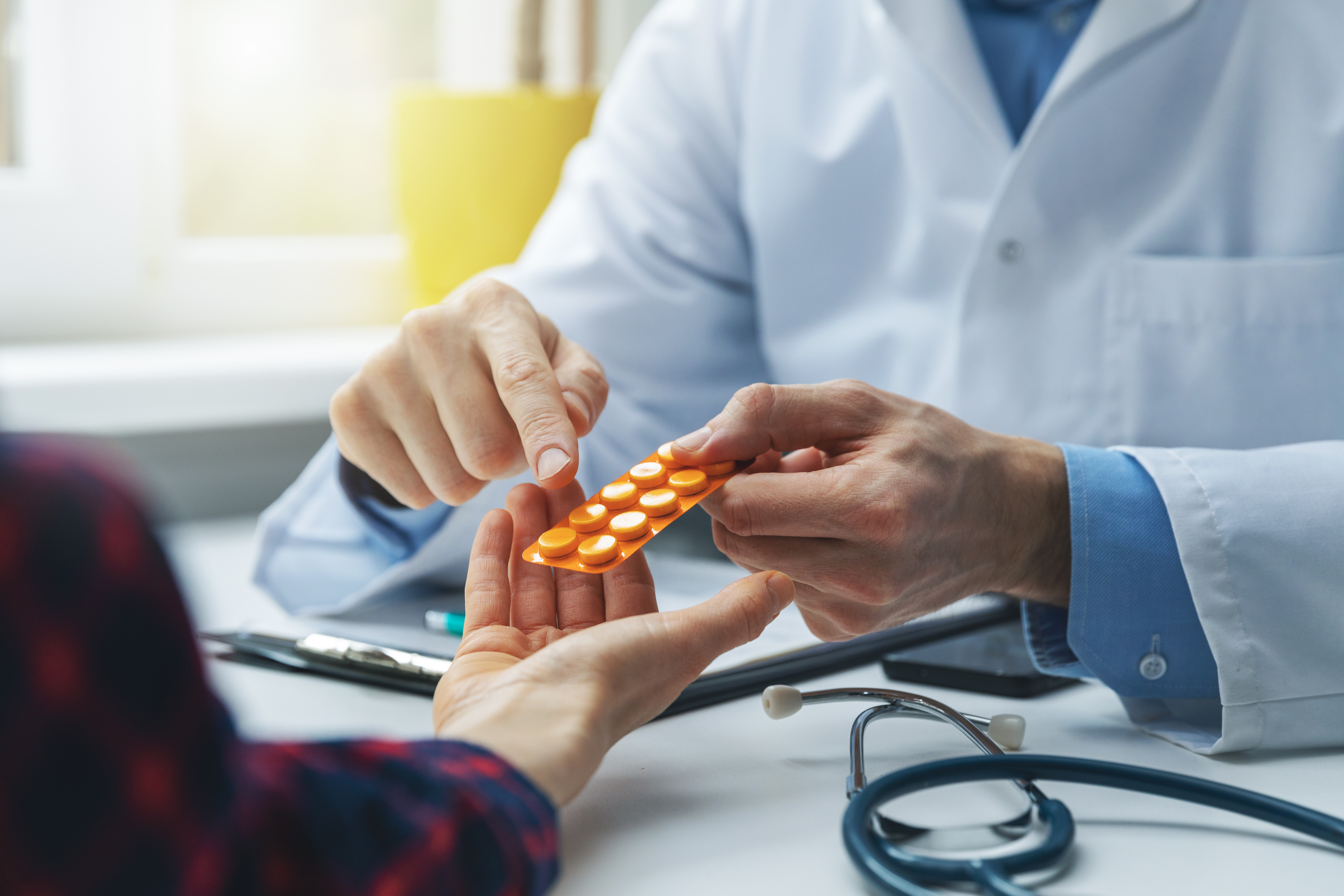 Pharmacist showing pill pack to patient
