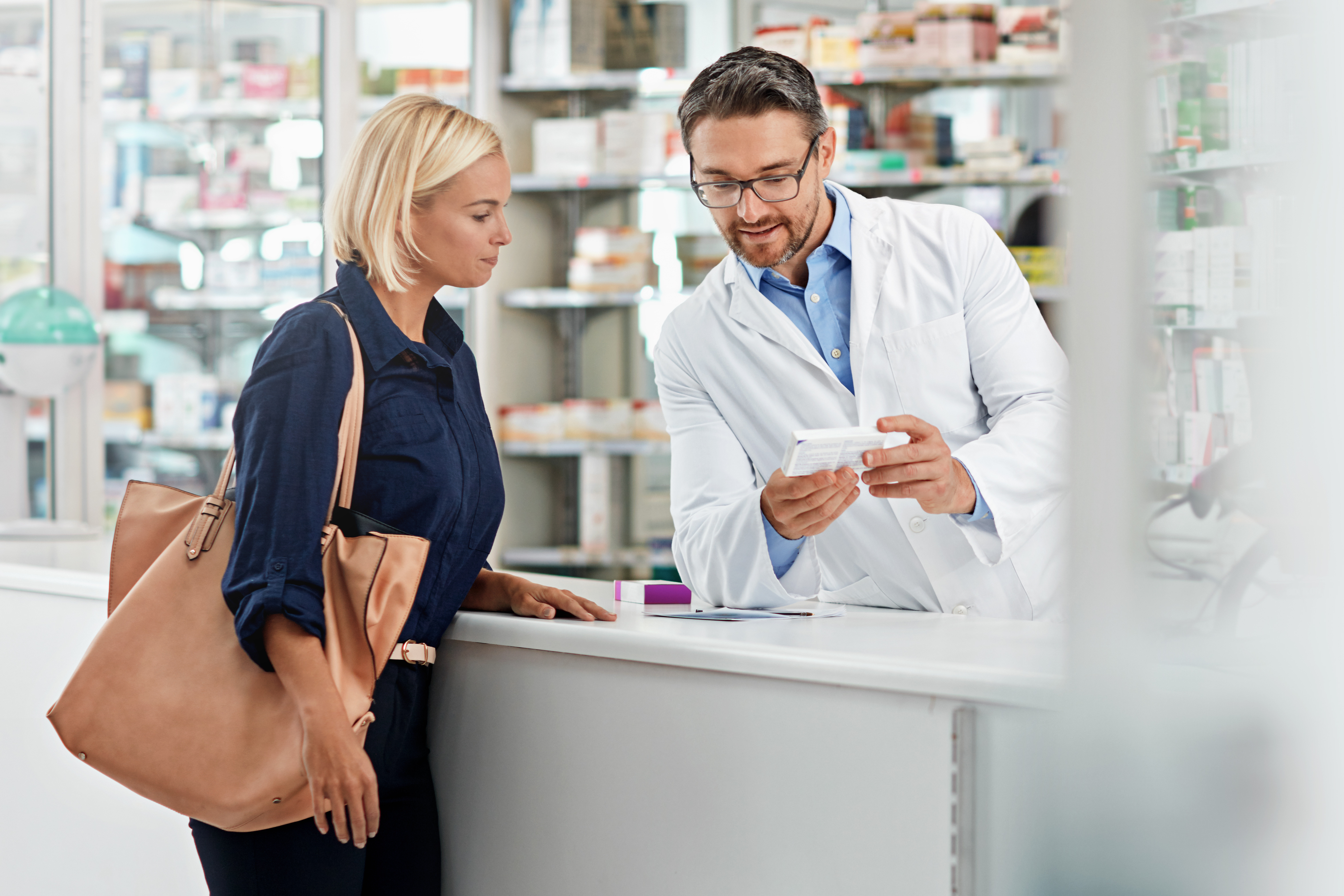 Man, pharmacist and help customer, prescription and explain instructions for medicine, vitamins and wellness.