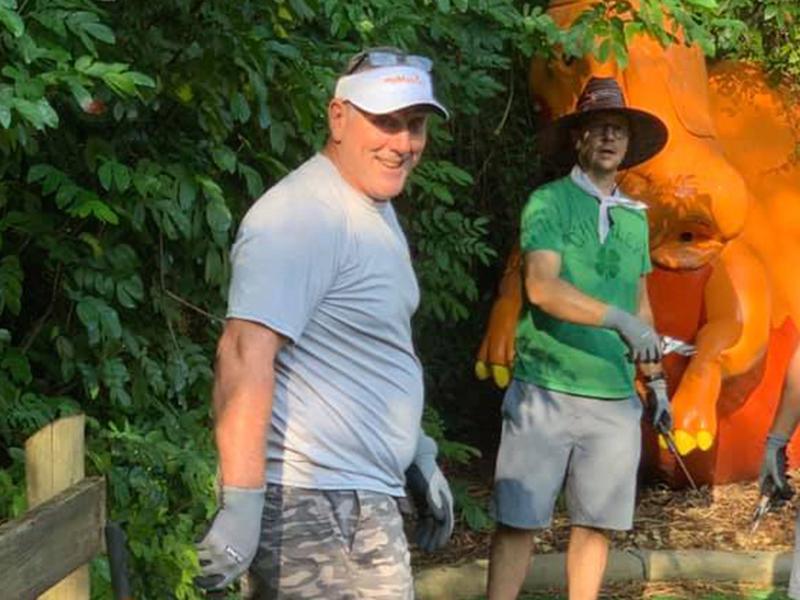 Two men wearing hats doing outdoor landscaping at a local zoo