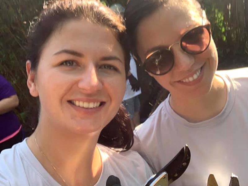 Two women smiling while holding gardening shears