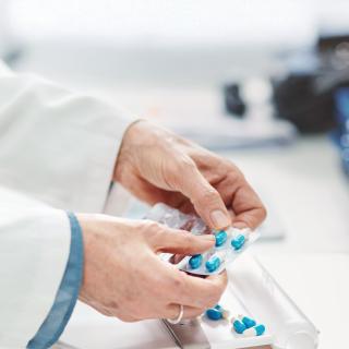 Pharmacist popping capsules out of package