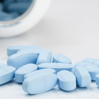 bottle tipped over with blue tablets