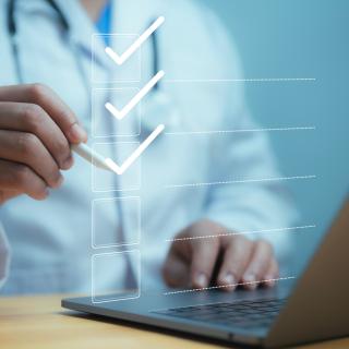 Medical worker using laptop with online checklist survey