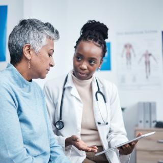 Black woman, doctor and senior patient with tablet, results and listen for health planning, advice or cancer