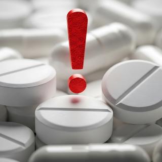 Warning sign with pharmaceutical pills emphasizes medical risk and medication caution